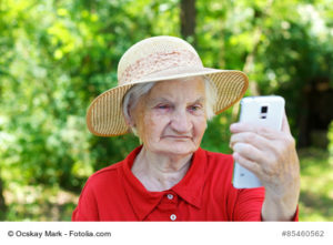 Beautiful elderly woman looking at a smartphone