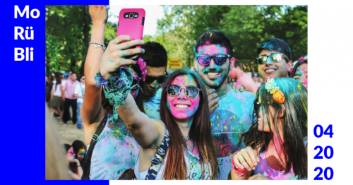 Eine Gruppe Menschen, die auf einem Festival mit verschiedenfarbigen Farbpulvern überschüttet wurden, machen ein Selfie.