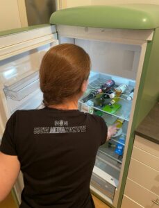 Social Media Konzepte: Mitarbeiterin Anne greift in den Kühlschrank